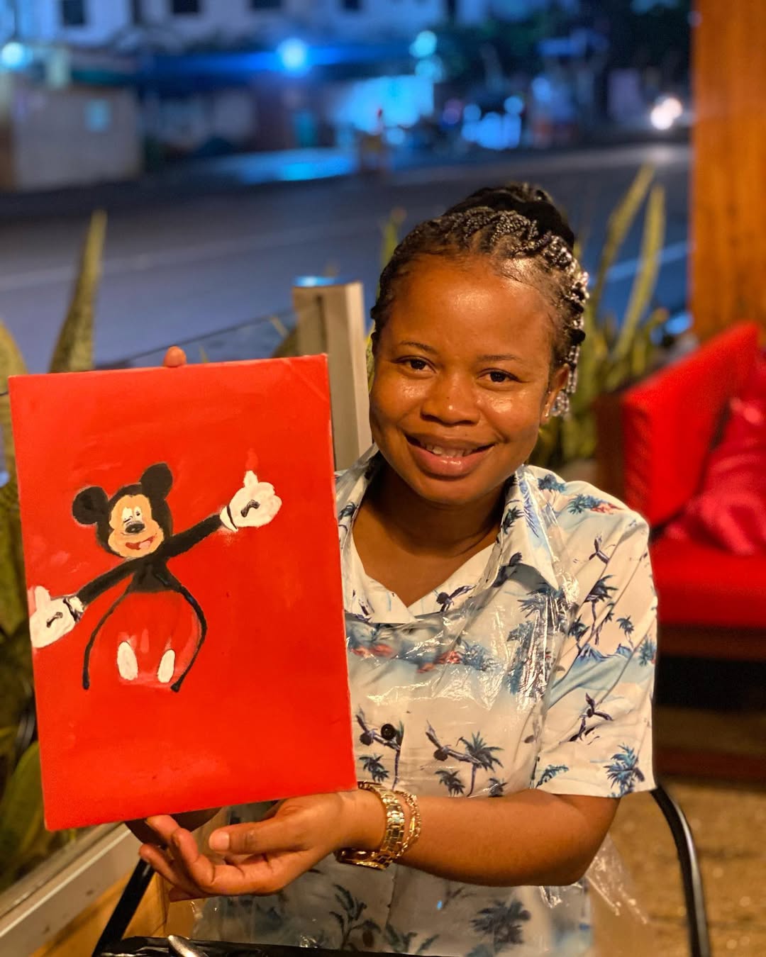 A painter holding her finished bold red pop-art canvas